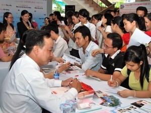 People scrambling to enquire for jobs at the 13th Job Exchange Floor in HCMC (File photo: VNA)